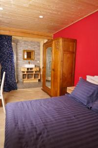 圣阿格雷夫Le Mazel的一间卧室设有蓝色的床和红色的墙壁