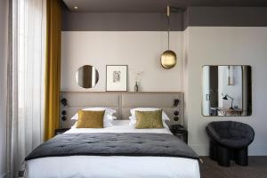 里昂Hôtel de l'Abbaye Lyon - Boutique Hôtel的一间卧室配有一张床、镜子和椅子