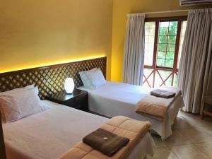普拉伊拉多比莱尼Bilene Dream House 1的酒店客房设有两张床和窗户。