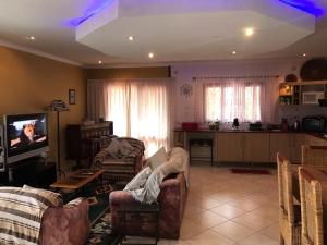 普拉伊拉多比莱尼Bilene Dream House 1的带沙发和电视的客厅以及厨房。