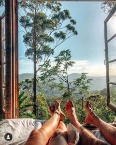 The PocketThe Den of the Treehouse, KINABALU Farm的躺在床上,从窗户望出去的人