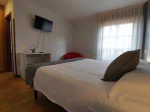 坎加斯-德奥尼斯Hotel El Trasgu的卧室配有白色的床和枕头