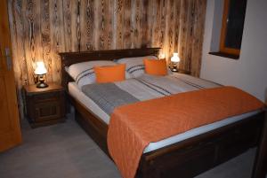 IspánkVadszőlős Porta的一间卧室配有一张带橙色枕头的床和两盏灯。
