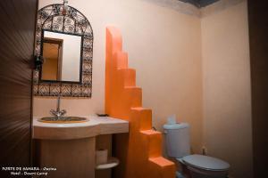 OuzinaPorte De Sahara Ouzina的一间带水槽、镜子和卫生间的浴室
