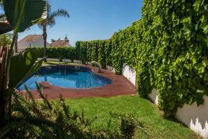 卡拉费尔Club Villamar - Capilla的一个带木甲板的庭院内的游泳池