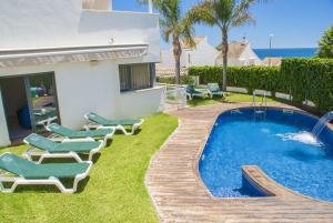 卡拉费尔Club Villamar - Capilla的一个带椅子的庭院、一个游泳池和一个房子