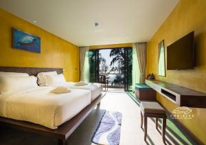 迈考海滩Coriacea Beachfront Boutique Phuket Resort - SHA Plus的一间卧室配有两张床和一台平面电视