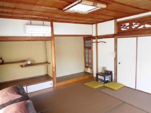 尾道市ゲストハウス尾道ポポー Guesthouse Onomichi Pawpaw的客房设有床和窗户。