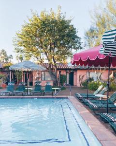 棕榈泉Les Cactus的房屋旁的游泳池配有椅子和遮阳伞
