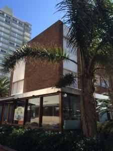 埃斯特角城Hotel Gaudí的前面有棕榈树的建筑