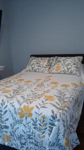 三河城The Sequoia Hut!的一张床上,上面有鲜花,上面有蓝色和白色的毯子