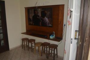 南圣弗朗西斯科Casa confortável na praia的电视机房间里一群凳子