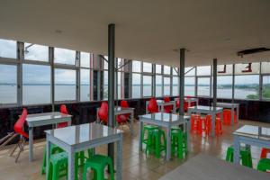 肯达利RedDoorz near Kendari Beach 2的餐厅设有桌子和红色椅子以及窗户。