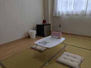 富士吉田市街のホテル的一间设有白色桌子和两把椅子的房间