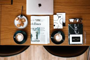特拉维夫特拉维夫莱昂纳多精品酒店的一张桌子,上面放着一杯咖啡和报纸