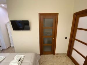 福贾B&B San Michele Foggia的一间房间,配有一张床和墙上的电视