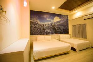 台中市安顺商务旅馆的墙上画画的房间里设有两张床