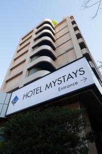 东京MYSTAYS 龟户酒店的大楼前的酒店烟 ⁇ 入口标志