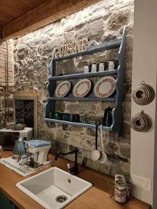 戈里齐亚1848 Chef's Rooms的一个带水槽的厨房和墙上的一些盘子