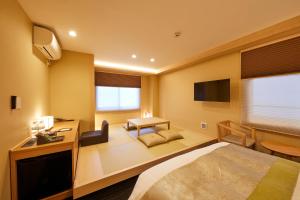 京都Rinn Shirakawa South的一间酒店客房,配有一张床和一台电视