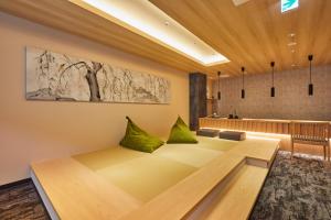 京都Rinn Shirakawa South的客房设有一张带绿色枕头的沙发。