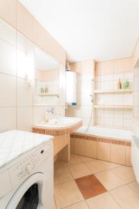 RymanówMiędzy Zdrojami的白色的浴室设有洗衣机和浴缸。