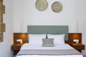 基萨莫斯Agarathos Deluxe Homes的一张带白色枕头和绿色床头板的床