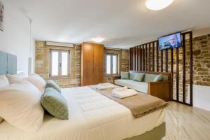 基萨莫斯Agarathos Deluxe Homes的卧室配有一张白色的大床和一张沙发。