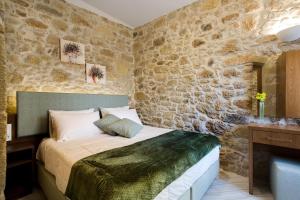 基萨莫斯Agarathos Deluxe Homes的一间卧室设有一张床和石墙