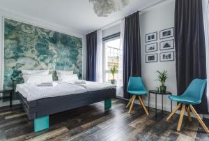 卡尔斯鲁厄zentrales 130 qm Design-Appartement mit Extras的一间卧室配有一张床和两张蓝色椅子