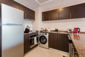 迪拜Quintessential Quarters - Breathtaking 29th Floor Views的厨房配有冰箱和洗衣机。