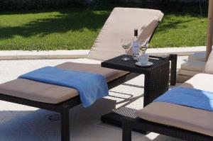 比亚拉Vello Apartments的柳条椅和桌子及两杯葡萄酒