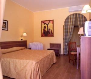 阿尔贝罗贝洛库尔迪普利亚酒店的酒店客房配有一张床铺和一张桌子。
