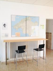 马略卡岛帕尔马圣特尔莫旅馆的一张桌子、两把椅子和一张墙上的地图