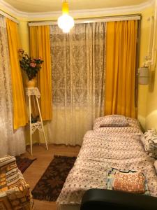KerekegyházaKereki Retro Vendégház的一间卧室设有床和黄色窗帘的窗户