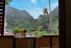 皮皮岛Chongkhao Resort- SHA Certified的两杯酒坐在窗前的桌子上