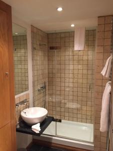 伦敦罗切斯特公寓的浴室配有水槽、淋浴和浴缸。