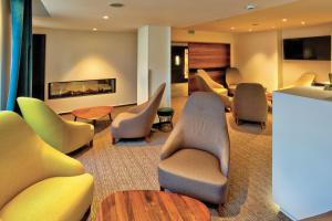 吕克瑟伊莱班Logis Hotel Restaurant Spa Beau Site的一间设有桌椅和壁炉的等候室