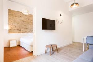 略夫雷加特河畔奥斯皮塔莱特Design Apartments by Olala Homes的一间卧室配有一张床,墙上配有电视