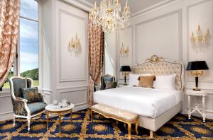 Mazières-en-GâtineAlexandra Palace - La Maison Younan的一间卧室配有一张床、两把椅子和一个吊灯