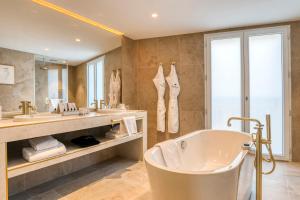 尼姆Maison Albar Hotels L’Imperator的一间带浴缸和大镜子的浴室