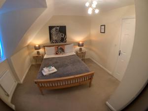 科比Harpers brook house, Netflix TVs and fast WIFI的一间卧室配有一张床和两张带台灯的桌子。