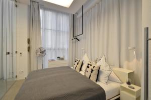 慕尼黑Luxury Omaruru-Design-Apartment Deluxe的卧室配有带枕头的床铺和窗户。