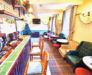 贝德福德米尔酒店的一间设有酒吧的房间,配有椅子和圣诞树