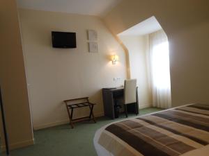 卢瓦尔河畔新堡公园酒店的一间卧室配有一张床、一张书桌和一台电视