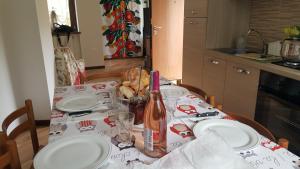 埃多洛Casa Ramus Valle Camonica a 30 km dal Passo Tonale的一张带白板的桌子和一瓶葡萄酒