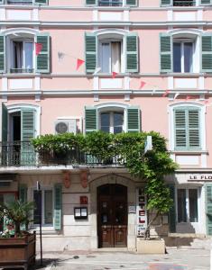弗雷瑞斯植物群酒店的粉红色的建筑,设有绿色百叶窗和门
