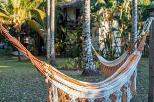 伊塔卡雷阿尔德亚多玛尔酒店的棕榈树庭院内的两张吊床