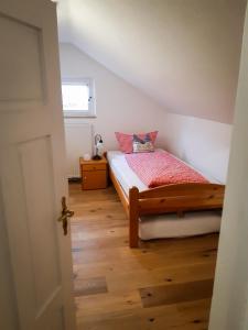 加尔米施-帕滕基兴Ferienwohnung Aurora的一间卧室配有一张床,铺有木地板