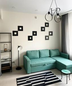 莫斯科Aparthotel Lind的客厅设有绿色沙发和带照片的墙壁